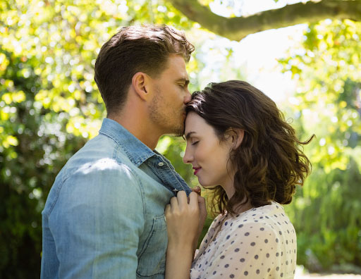 A man kissing the forehead of a woman